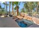 Relaxing outdoor hot tub with rock accents, adjacent to a patio area with a grill at 7608 Painted Dunes Dr, Las Vegas, NV 89149