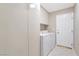 Laundry room with built-in cabinets and an exterior door at 7608 Painted Dunes Dr, Las Vegas, NV 89149