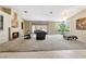 Spacious living room with fireplace, plush seating, and view of the outdoor living area at 7608 Painted Dunes Dr, Las Vegas, NV 89149
