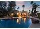 A backyard pool reflects the home, enhanced with stone accents and lush landscaping at 7608 Painted Dunes Dr, Las Vegas, NV 89149