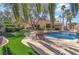 Backyard with a private pool, a rock waterfall, manicured landscaping, and a lounge chair on the patio at 7608 Painted Dunes Dr, Las Vegas, NV 89149
