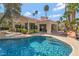 A view of the pool featuring a rock waterfall feature and lush landscaping in the background at 7608 Painted Dunes Dr, Las Vegas, NV 89149