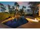 A beautiful swimming pool is surrounded by lush greenery and palm trees, creating a private oasis at 7608 Painted Dunes Dr, Las Vegas, NV 89149