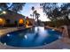 Backyard swimming pool with integrated rock waterfall feature and ambient lighting at 7608 Painted Dunes Dr, Las Vegas, NV 89149
