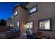 An outdoor patio with seating and a stainless steel grill show the backyard of this tan stucco home at 7731 Ornamento Way, Las Vegas, NV 89179