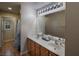 Bathroom with a dual sink vanity, large mirror and wood-style flooring at 7731 Ornamento Way, Las Vegas, NV 89179