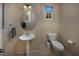 Cozy powder room featuring a pedestal sink, oval mirror, and natural light at 7731 Ornamento Way, Las Vegas, NV 89179