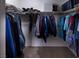 Walk-in closet with carpet, shelving, and organized hanging clothes at 7731 Ornamento Way, Las Vegas, NV 89179