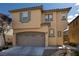 Inviting two-story home featuring a neutral color scheme, arched garage door, and well-maintained landscaping at 7731 Ornamento Way, Las Vegas, NV 89179