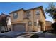 Two-story home with an attached garage, showcasing the front facade, landscaping, and a clear blue sky at 7731 Ornamento Way, Las Vegas, NV 89179