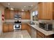 Well-lit kitchen featuring stainless steel appliances and oak cabinets at 7731 Ornamento Way, Las Vegas, NV 89179