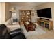 Comfortable living room features a large TV, wooden bookshelf, and decorative coffee table at 7731 Ornamento Way, Las Vegas, NV 89179