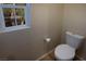 This bathroom includes a standard white toilet and a window for natural light at 7731 Ornamento Way, Las Vegas, NV 89179