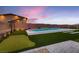 Backyard with a pool, putting green, modern landscaping, and accent lighting at 7966 W Ford Ave, Las Vegas, NV 89113