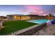 Backyard features a pool, putting green, desert landscaping, and a custom gabion wall at 7966 W Ford Ave, Las Vegas, NV 89113