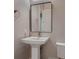 Powder room showcasing a pedestal sink, a framed mirror, and a classic towel holder at 7966 W Ford Ave, Las Vegas, NV 89113