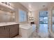A spacious bathroom with dual vanities, a soaking tub, and large windows with plantation shutters at 7966 W Ford Ave, Las Vegas, NV 89113