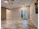 Spacious bedroom features stone floors, barn door, ceiling fan, and shuttered French doors at 7966 W Ford Ave, Las Vegas, NV 89113