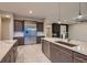 Modern kitchen with stainless steel refrigerator, stone countertops, and access to the living area at 7966 W Ford Ave, Las Vegas, NV 89113
