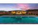 Backyard view of a pool and covered patio, with glass doors to the interior and a colorful sunset at 7966 W Ford Ave, Las Vegas, NV 89113
