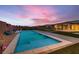 Backyard pool with blue water, brick walkway, and patio under a colorful sunset sky at 7966 W Ford Ave, Las Vegas, NV 89113