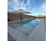 Backyard swimming pool featuring a modern design with built-in umbrellas and gray stone coping under a blue sky at 7966 W Ford Ave, Las Vegas, NV 89113
