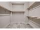 Functional walk-in closet with wooden racks for clothes and gray tile flooring at 7966 W Ford Ave, Las Vegas, NV 89113