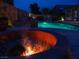 Inviting backyard featuring a sparkling pool, fire pit, and outdoor seating area, perfect for entertaining at 8070 Pavarotti Ave, Las Vegas, NV 89178