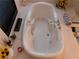 Well-lit bathroom with a soaking tub, fireplace, and elegant marble countertop at 8070 Pavarotti Ave, Las Vegas, NV 89178