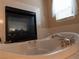 Relaxing bathroom featuring a luxurious soaking tub with a fireplace for ultimate comfort at 8070 Pavarotti Ave, Las Vegas, NV 89178