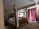 Spacious primary bedroom featuring a decorative four-poster bed and lots of natural light at 8070 Pavarotti Ave, Las Vegas, NV 89178