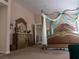Elegant primary bedroom with a decorative wooden dresser and a beautifully adorned four-poster bed at 8070 Pavarotti Ave, Las Vegas, NV 89178
