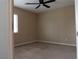 Neutral-toned bedroom with a ceiling fan, a window, and carpeted flooring, creating a cozy ambiance at 8070 Pavarotti Ave, Las Vegas, NV 89178