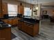 Well-appointed kitchen boasting an island, wood cabinets, modern appliances, and wood flooring at 8070 Pavarotti Ave, Las Vegas, NV 89178