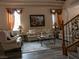 Comfortable living room with a decorative fireplace, plush seating, and staircase access at 8070 Pavarotti Ave, Las Vegas, NV 89178