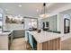 Modern kitchen with large island, seating, green cabinets and stainless appliances at 8324 Slate Harbor Cir, Las Vegas, NV 89128