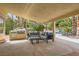 Covered outdoor living space with a built-in grill and comfortable seating area at 8324 Slate Harbor Cir, Las Vegas, NV 89128