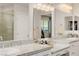 A bright bathroom featuring double sinks with speckled granite countertops and plenty of cabinet space at 864 Firestone Ledge Ave, Henderson, NV 89012