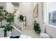 Bright entryway boasts soaring ceilings, neutral tile, and a staircase leading to the upper level with a fresh white banister at 864 Firestone Ledge Ave, Henderson, NV 89012