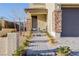 Inviting front entrance with brick accents, stone walkway, and manicured greenery, creating a warm welcome at 864 Firestone Ledge Ave, Henderson, NV 89012