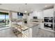 Elegant kitchen features white cabinets, stainless steel appliances, granite countertops, and an island with bar seating and backyard access at 864 Firestone Ledge Ave, Henderson, NV 89012