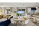 Open-concept living and dining area with sleek tile flooring, contemporary furnishings, and sliding glass doors for natural light and views at 864 Firestone Ledge Ave, Henderson, NV 89012
