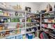 Walk-in pantry with shelving stocked full with an abundance of foods and household goods at 864 Firestone Ledge Ave, Henderson, NV 89012