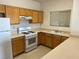 Galley kitchen featuring a gas range, light wood cabinetry, and laminate countertops at 8725 W Flamingo Rd # 226, Las Vegas, NV 89147