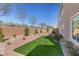 Landscaped backyard featuring synthetic grass and desert landscaping at 9853 Russian Hill St, Las Vegas, NV 89141