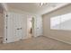 Bright bedroom with neutral carpet, multiple doors, and a large window at 9853 Russian Hill St, Las Vegas, NV 89141