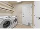 Laundry room with washer, dryer, shelving, and pet door at 9853 Russian Hill St, Las Vegas, NV 89141