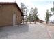 Exterior shot of a single story home with gravel landscaping and mature trees at 1081 Pluto St, Pahrump, NV 89048