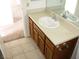 Bathroom vanity with a white sink, wood cabinets, and tile flooring at 1081 Pluto St, Pahrump, NV 89048