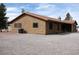 Exterior shot of a tan single story home with a brown tile roof and gravel landscaping at 1081 Pluto St, Pahrump, NV 89048